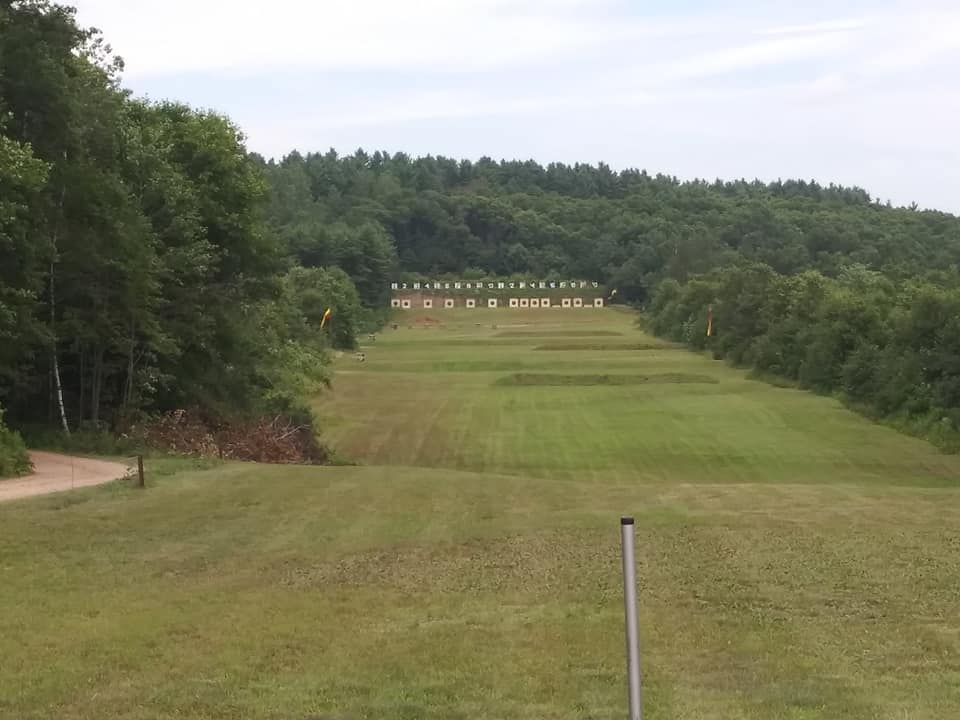 long narrow grassy field with forest on either side.